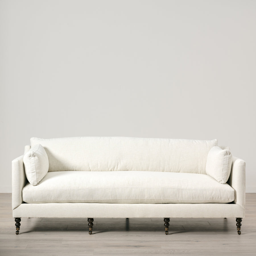 White sofa with decorative pillows on a light gray background