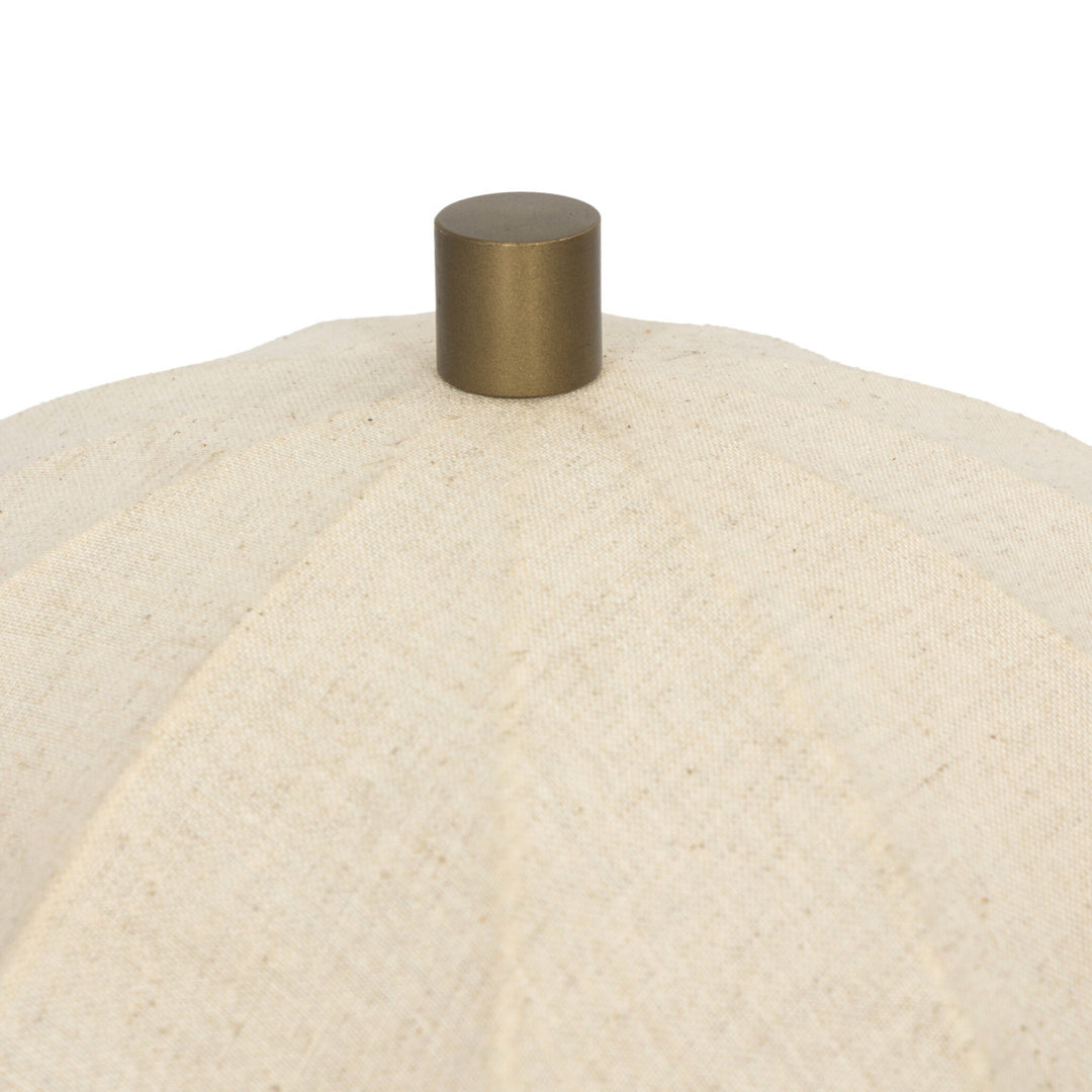 Close-up of a beige textured surface with a metallic gold knob on a white background