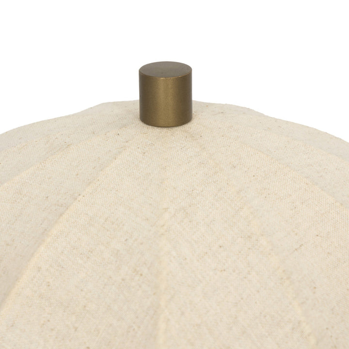 Close-up of a beige textured surface with a metallic gold knob on a white background