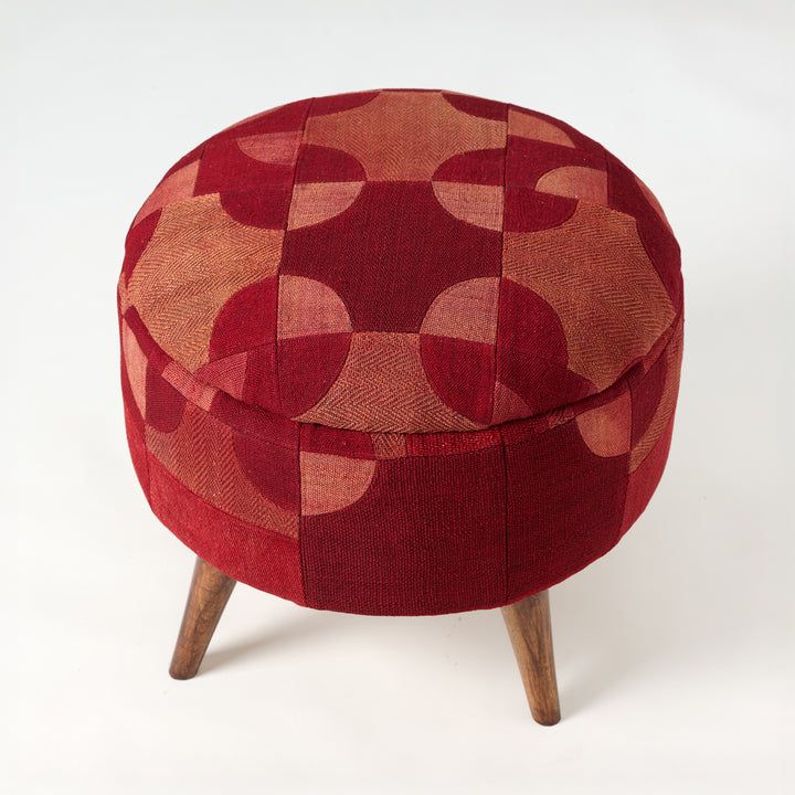 Round ottoman with a red and brown geometric pattern on a white background