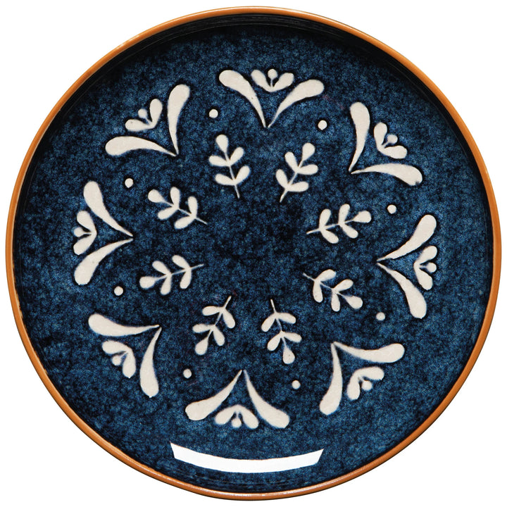 Decorative plate with white floral patterns on a blue background