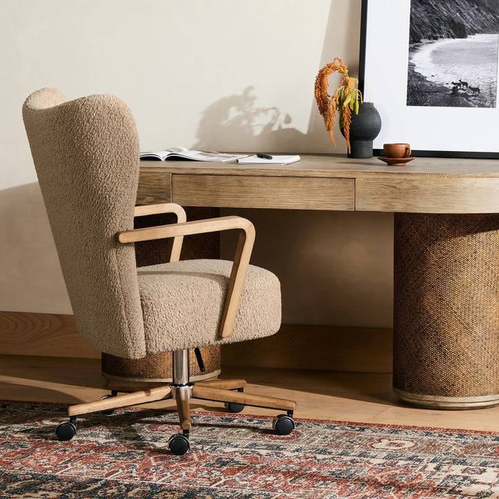 Beige office chair in front of a wooden desk with decorative items.