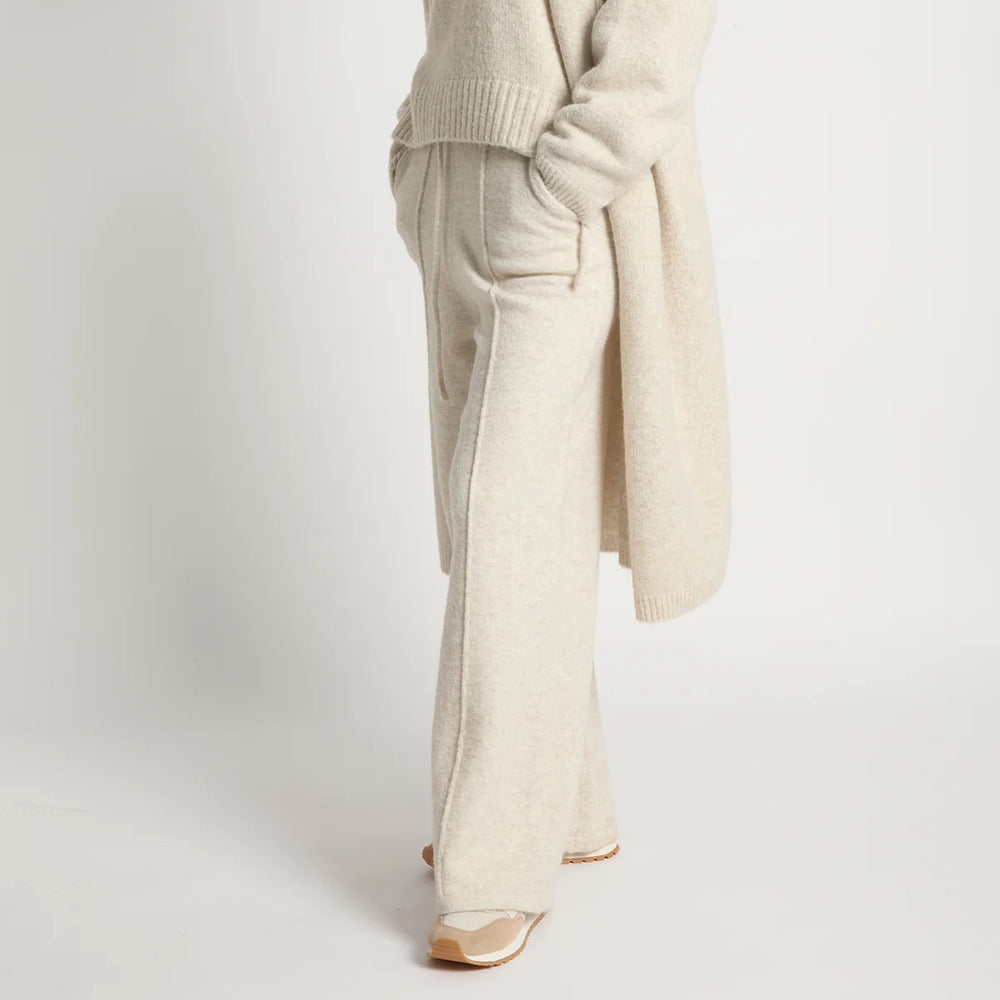 Beige sweater and pants with gold shoes on a white background