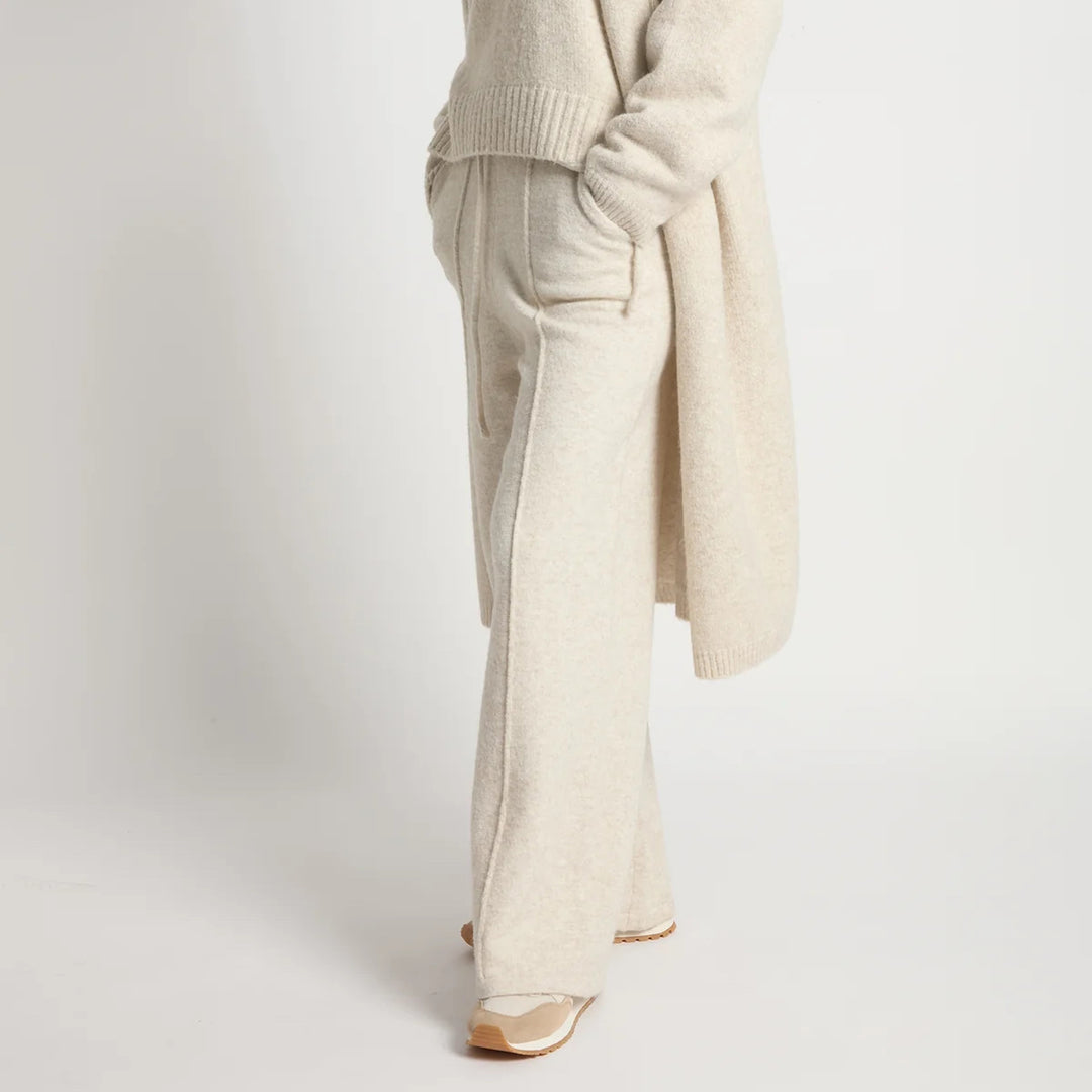 Beige sweater and pants with gold shoes on a white background