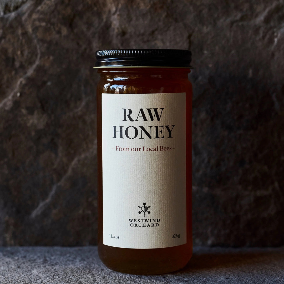 Jar of raw honey with a label on a textured surface