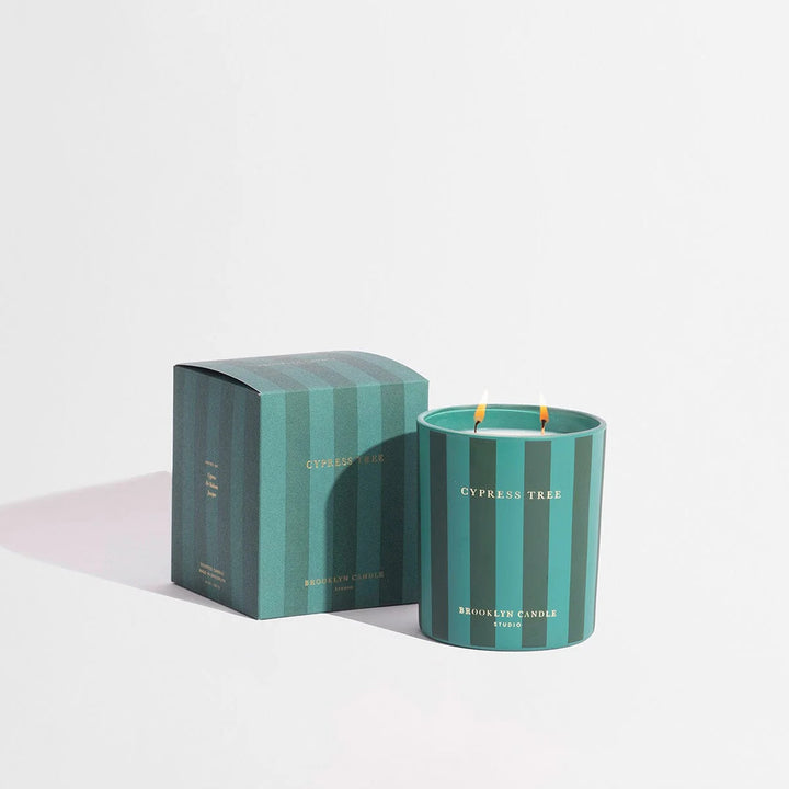Cypress Tree candle with matching striped packaging on a white background