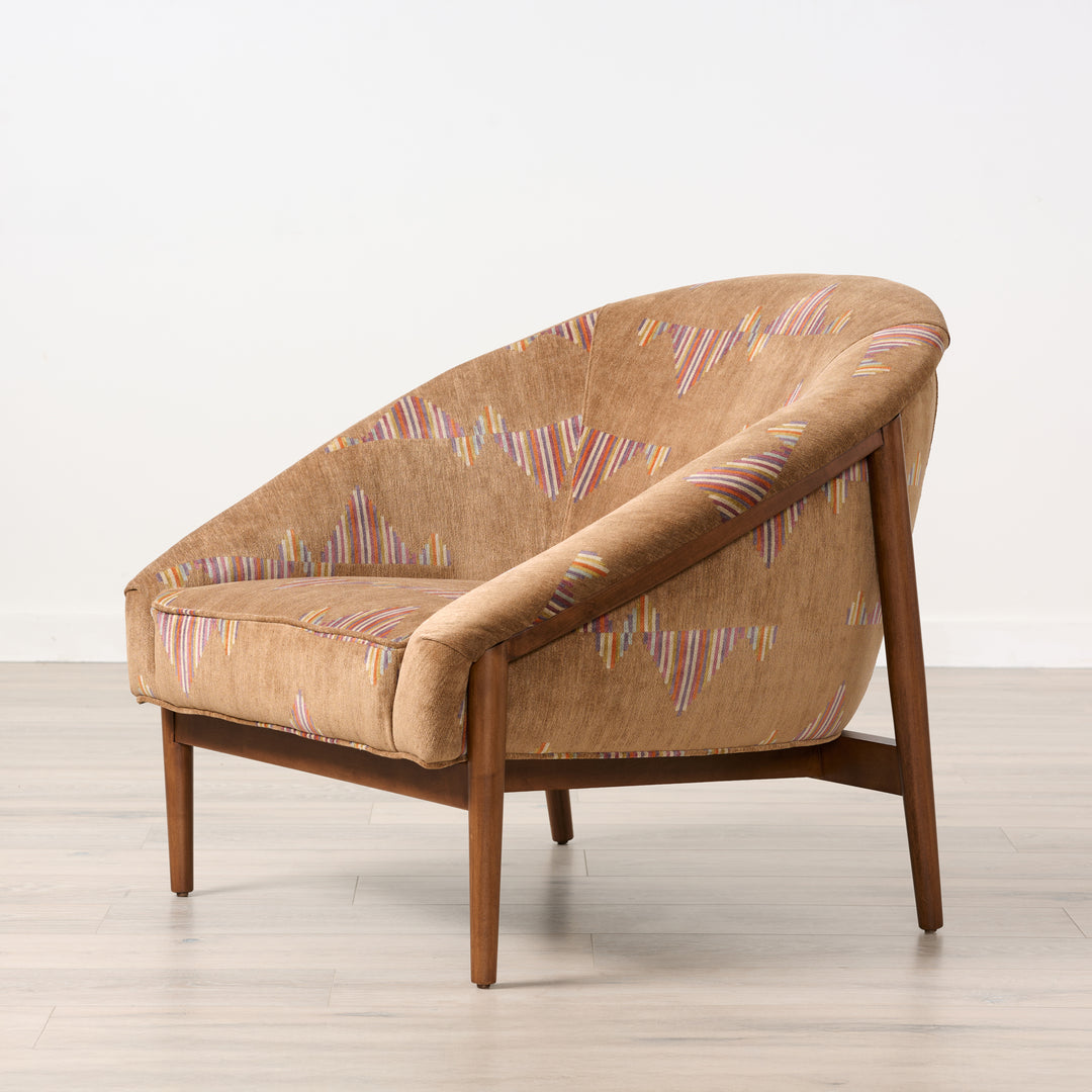 Brown armchair with patterned upholstery on a light wooden floor.