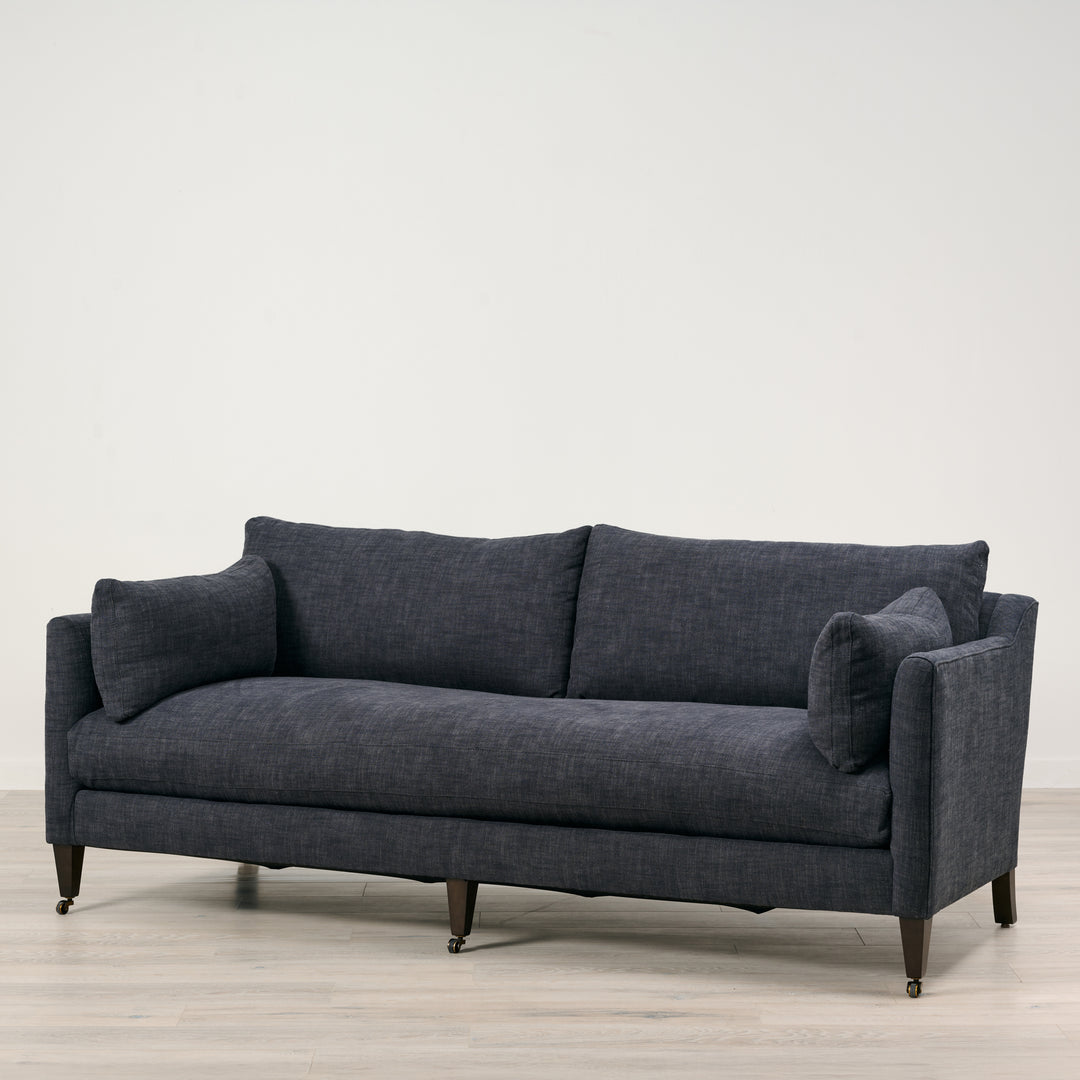 Gray sofa on a light wooden floor with a white background