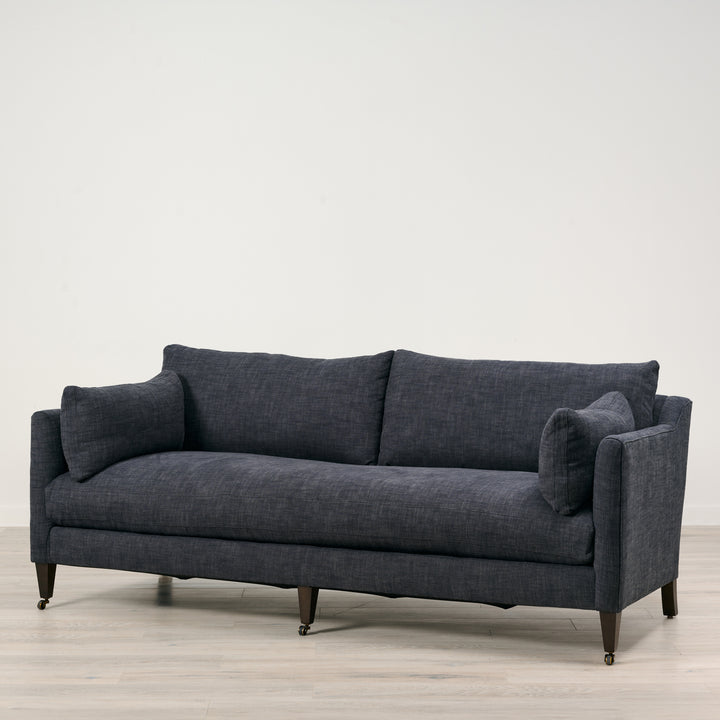 Gray sofa on a light wooden floor with a white background