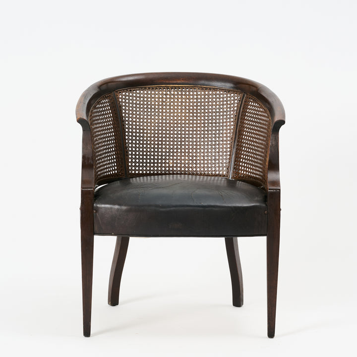 Chair with wicker back and black leather seat on a white background