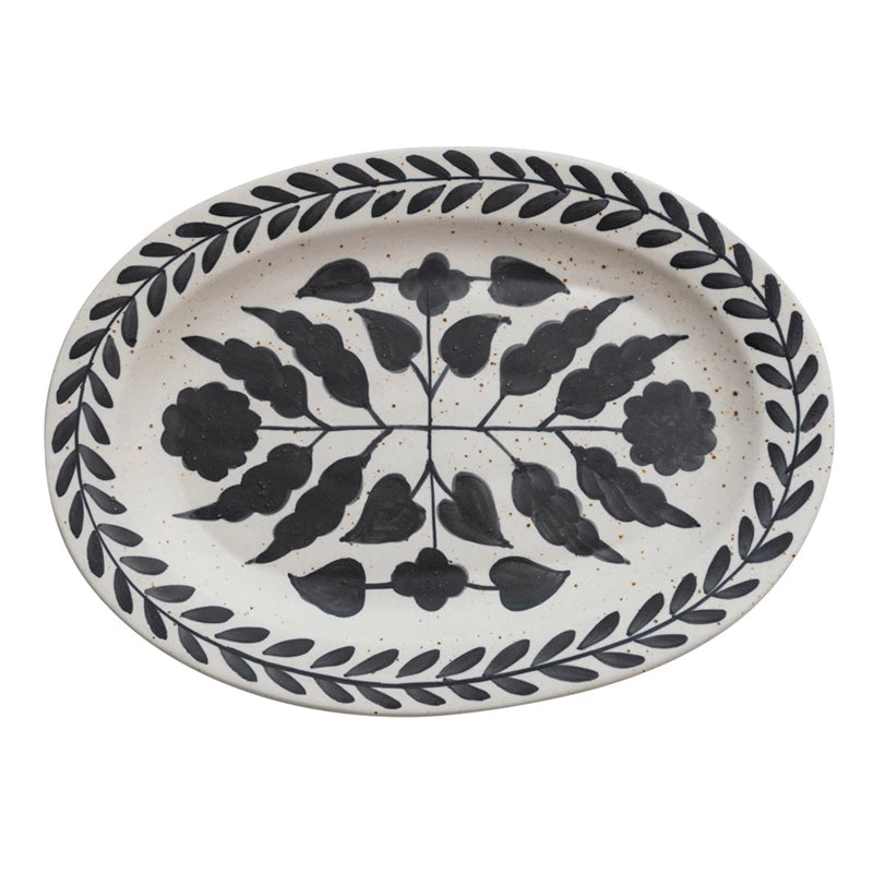 Oval ceramic plate with black floral pattern on a white background