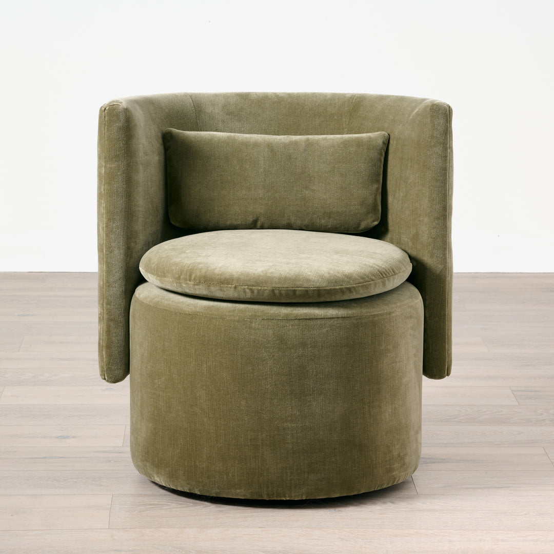 Green velvet armchair on a wooden floor with a white background