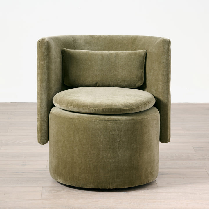 Green velvet armchair on a wooden floor with a white background