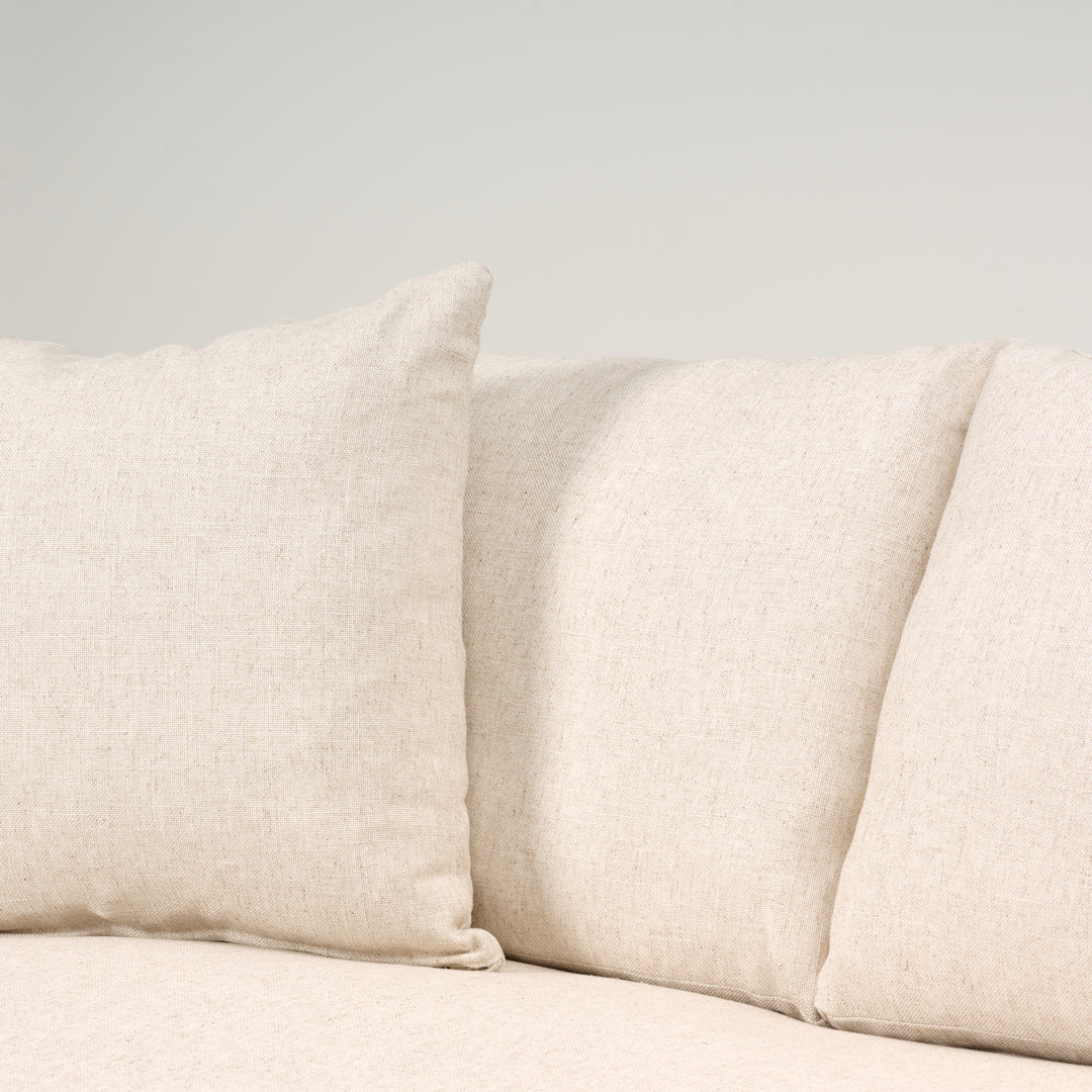 Close-up of beige fabric cushions on a neutral background