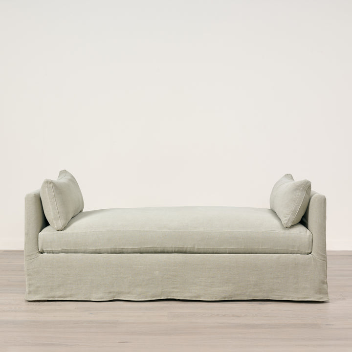 Light gray sofa with two cushions on a plain background