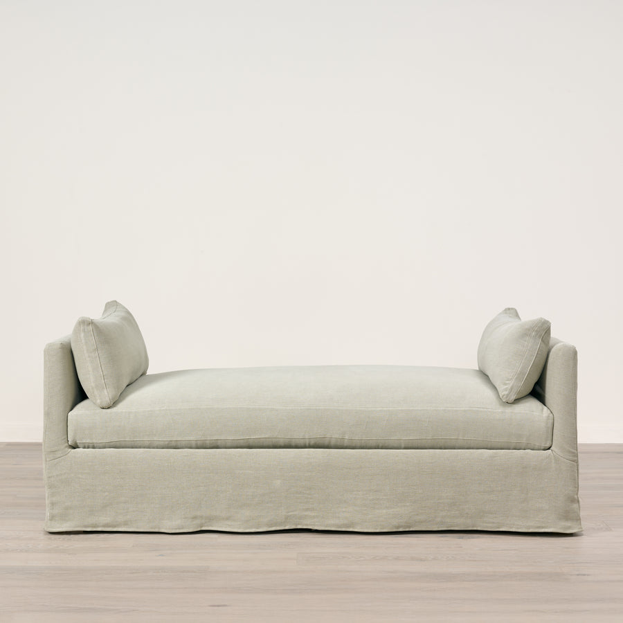 Light gray sofa with two cushions on a plain background