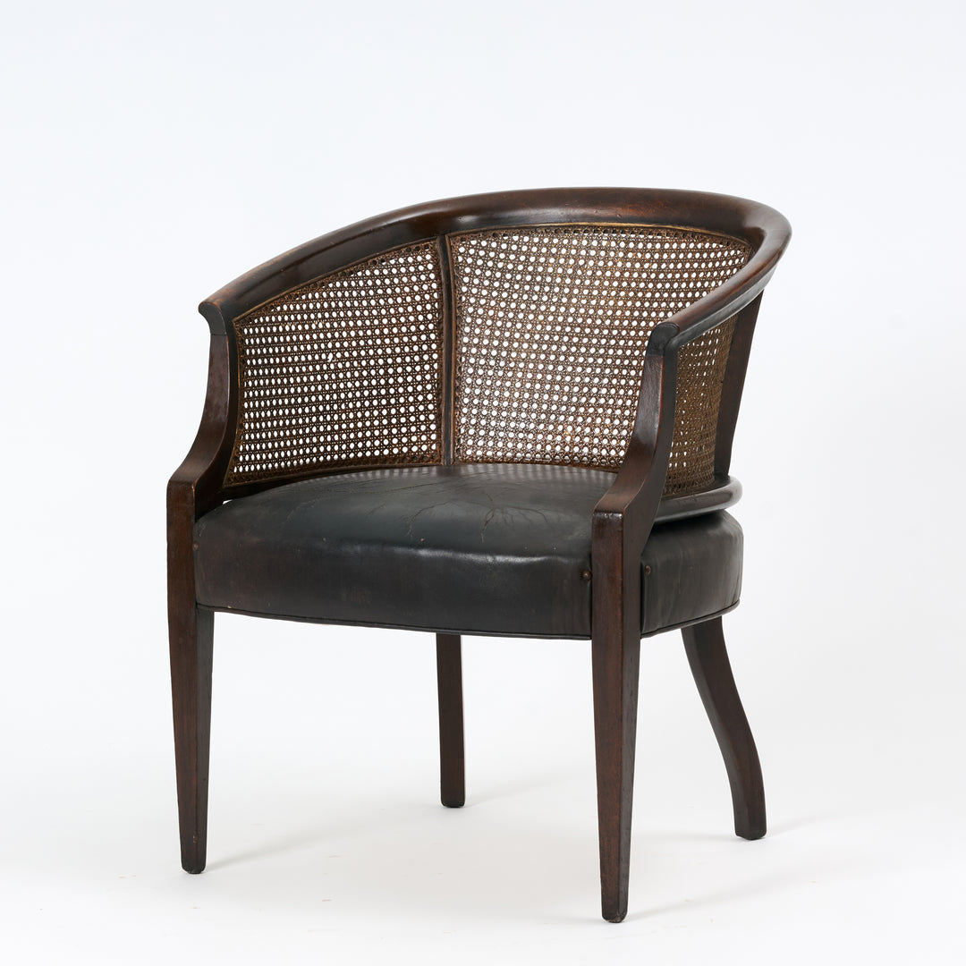 Chair with wicker back and dark leather seat on a white background