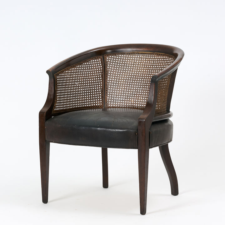 Chair with wicker back and dark leather seat on a white background
