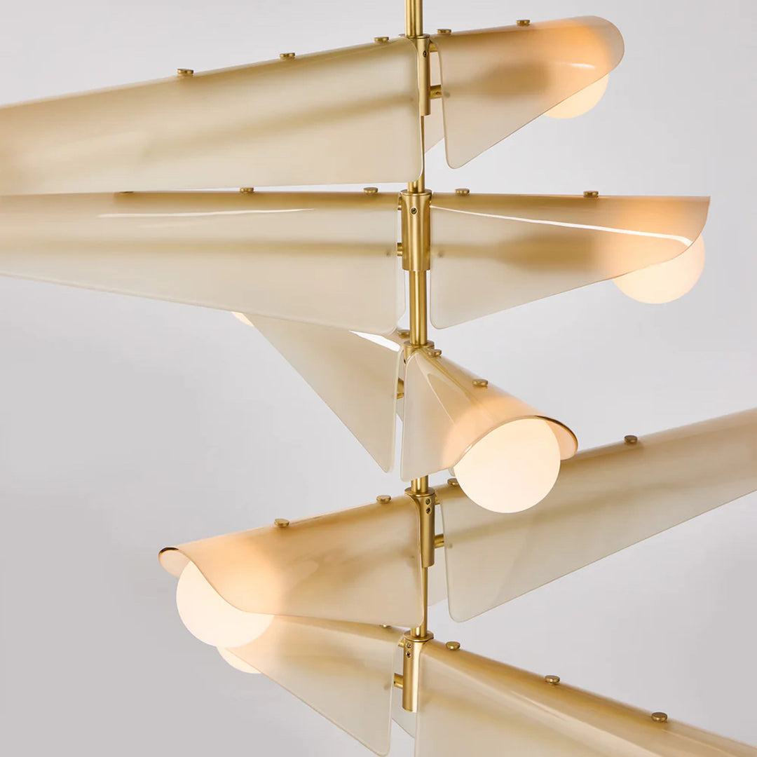 Modern chandelier with beige glass shades and gold metal accents on a light gray background