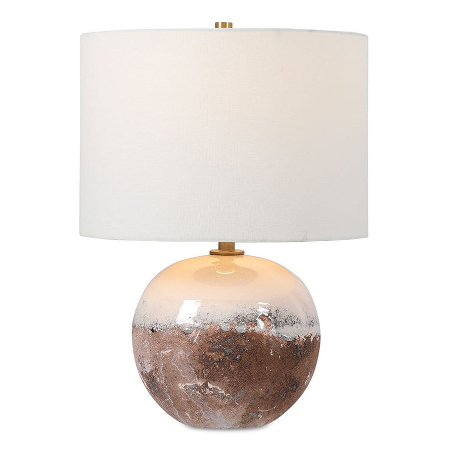 Table lamp with a textured ceramic base and white shade on a white background