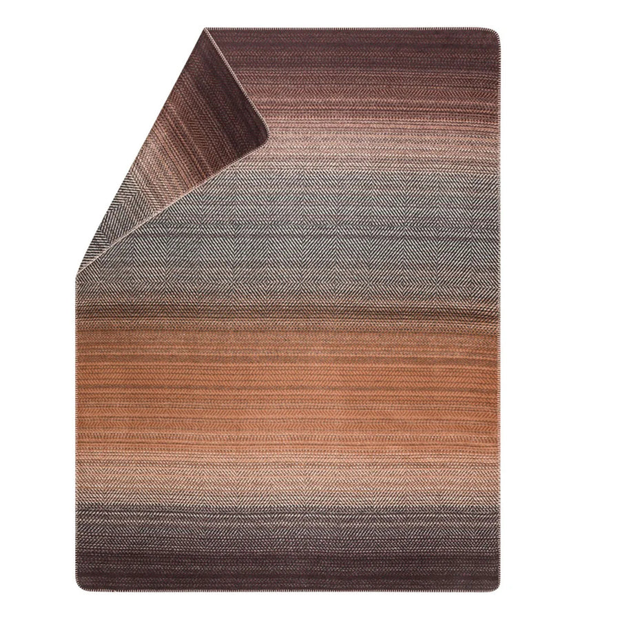 Gradient blanket with brown to gray pattern on a white background