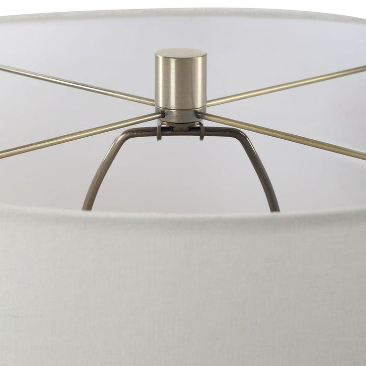 Close-up of a lamp with metallic base and clear glass shade on a white background