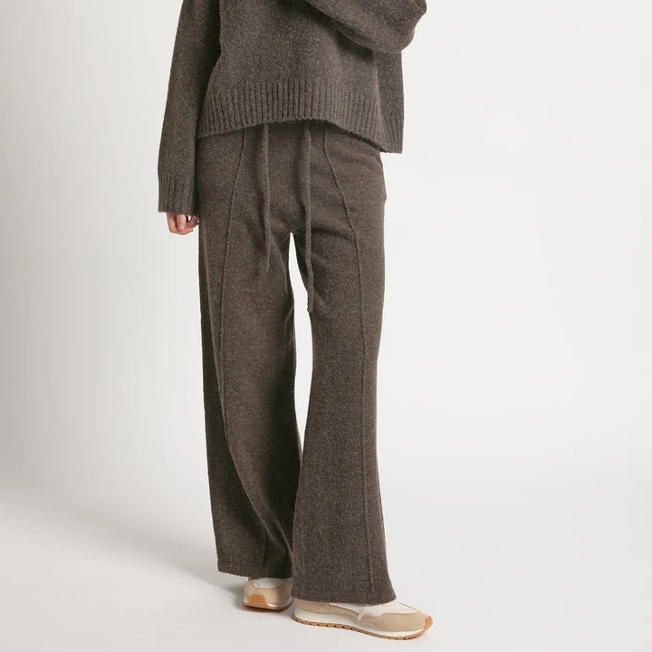 Brown knitted sweater and pants set on a white background