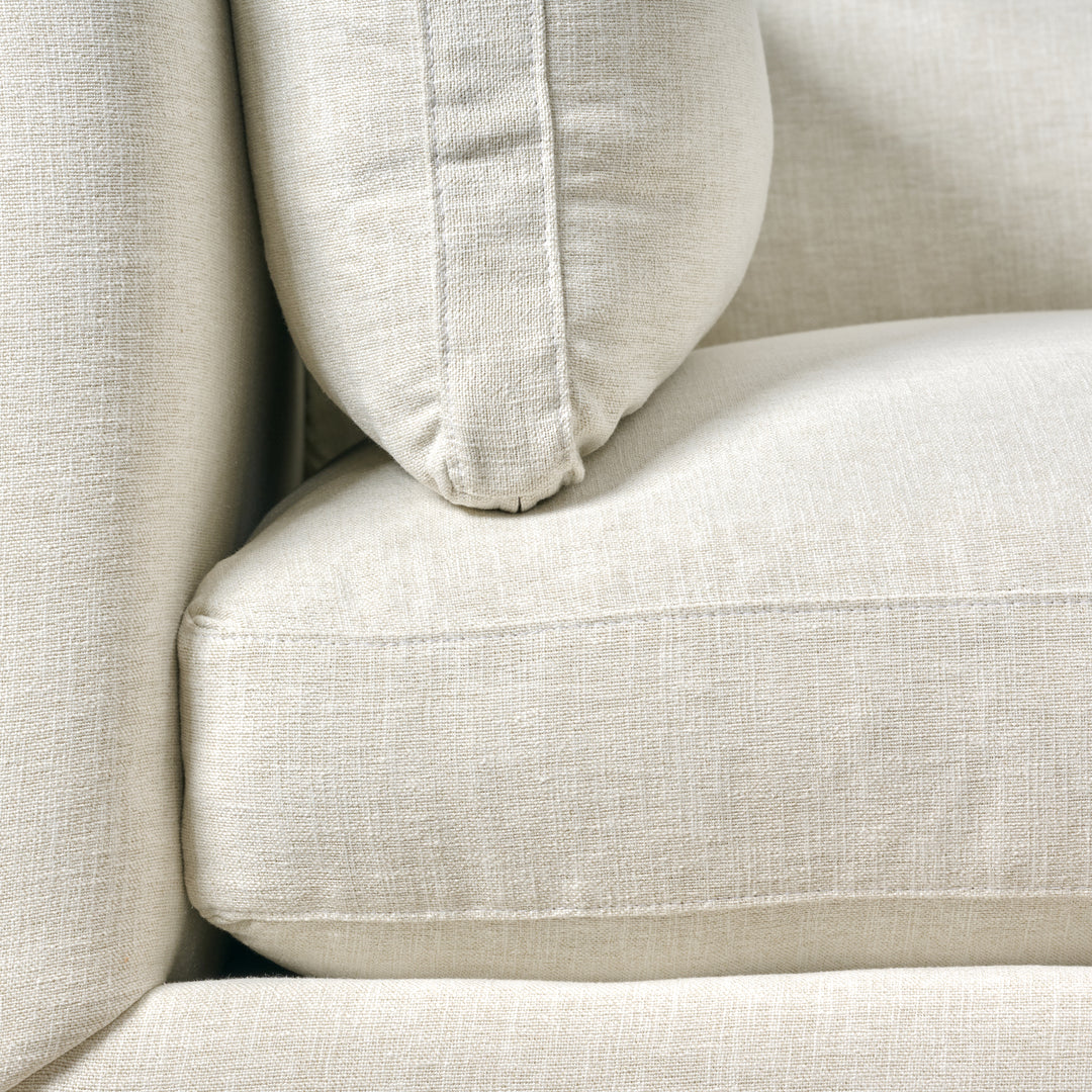 Close-up of a beige sofa with a pillow