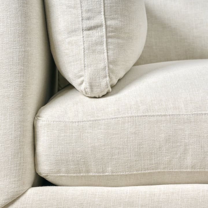 Close-up of a beige sofa with a pillow