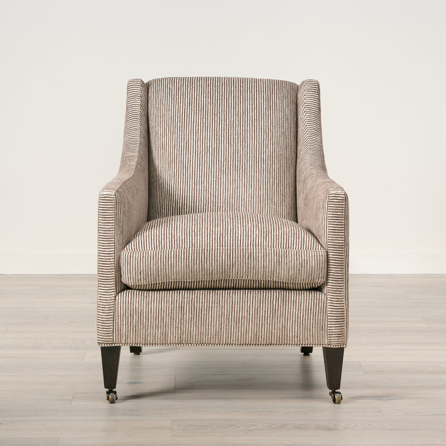 Patterned armchair on a wooden floor with a neutral background