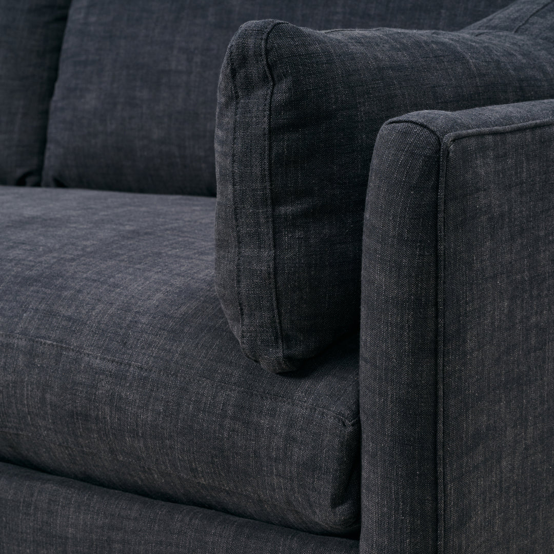 Close-up of a dark gray fabric sofa with a textured pattern.
