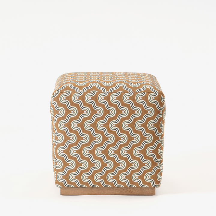 Cube-shaped ottoman with a wavy pattern on a white background
