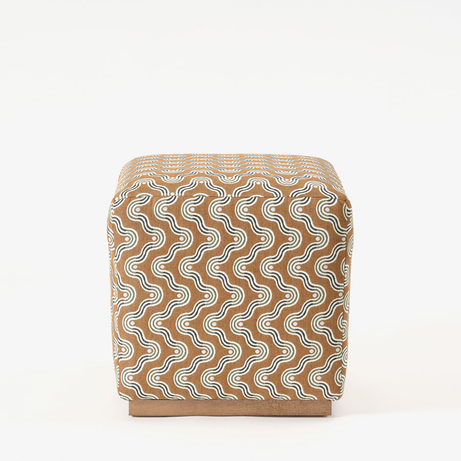 Cube-shaped ottoman with a wavy pattern on a white background