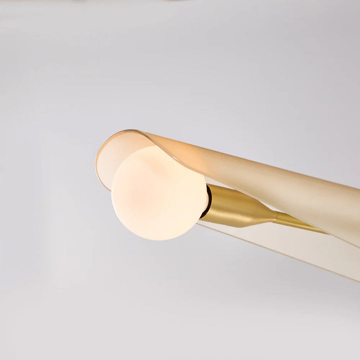 Modern ceiling light fixture with gold finish on a gray background