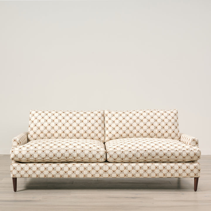 Patterned sofa on a wooden floor with a neutral background