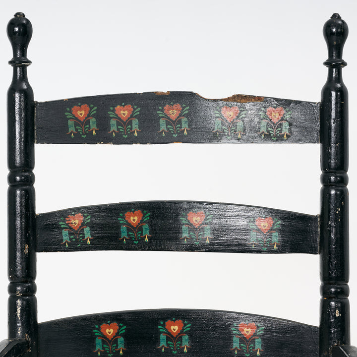 Black wooden chair with decorative heart patterns on a white background