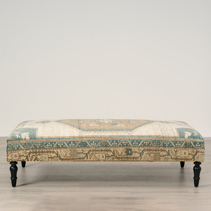 Patterned ottoman on a wooden floor with a neutral background