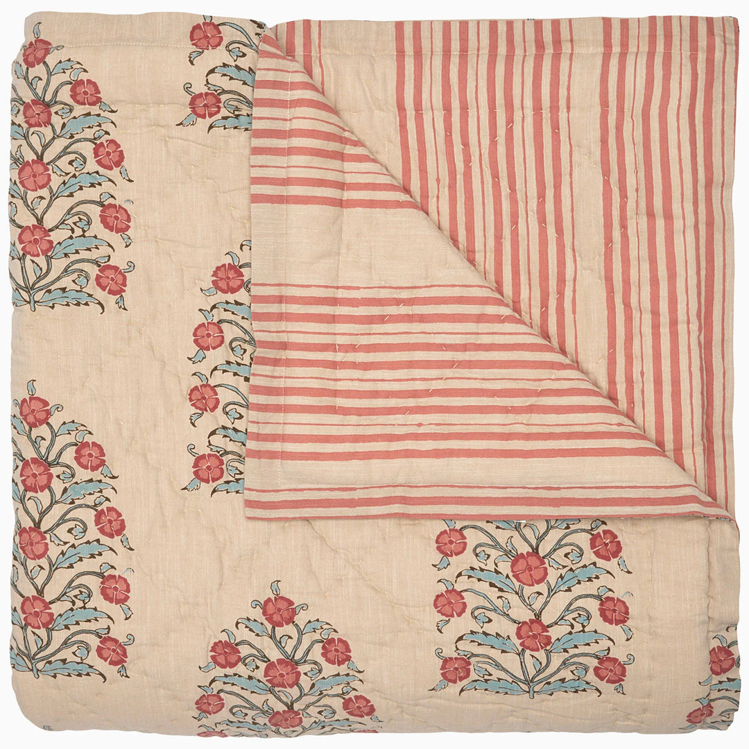 Textile with floral embroidery and striped pattern quilt on a white background