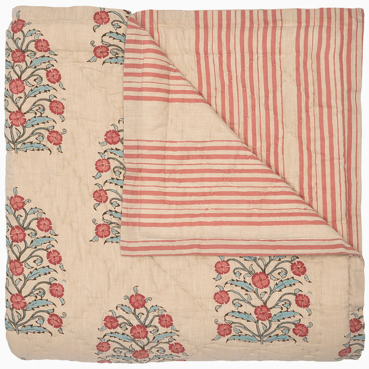Textile with floral embroidery and striped pattern quilt on a white background