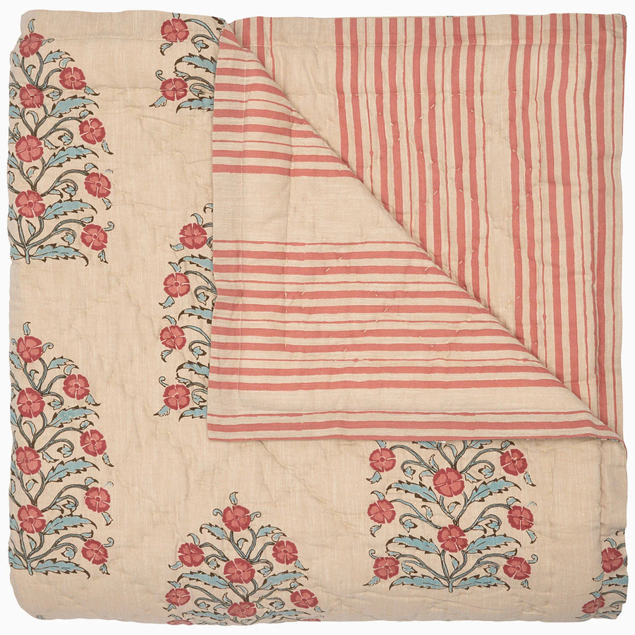 Textile with floral embroidery and striped pattern quilt on a white background