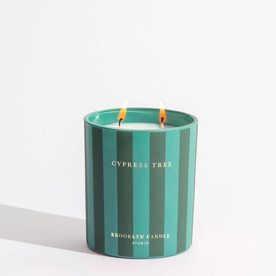 Striped candle with 'Cypress Tree' and 'Brooklyn Candle Studio' text on a white background