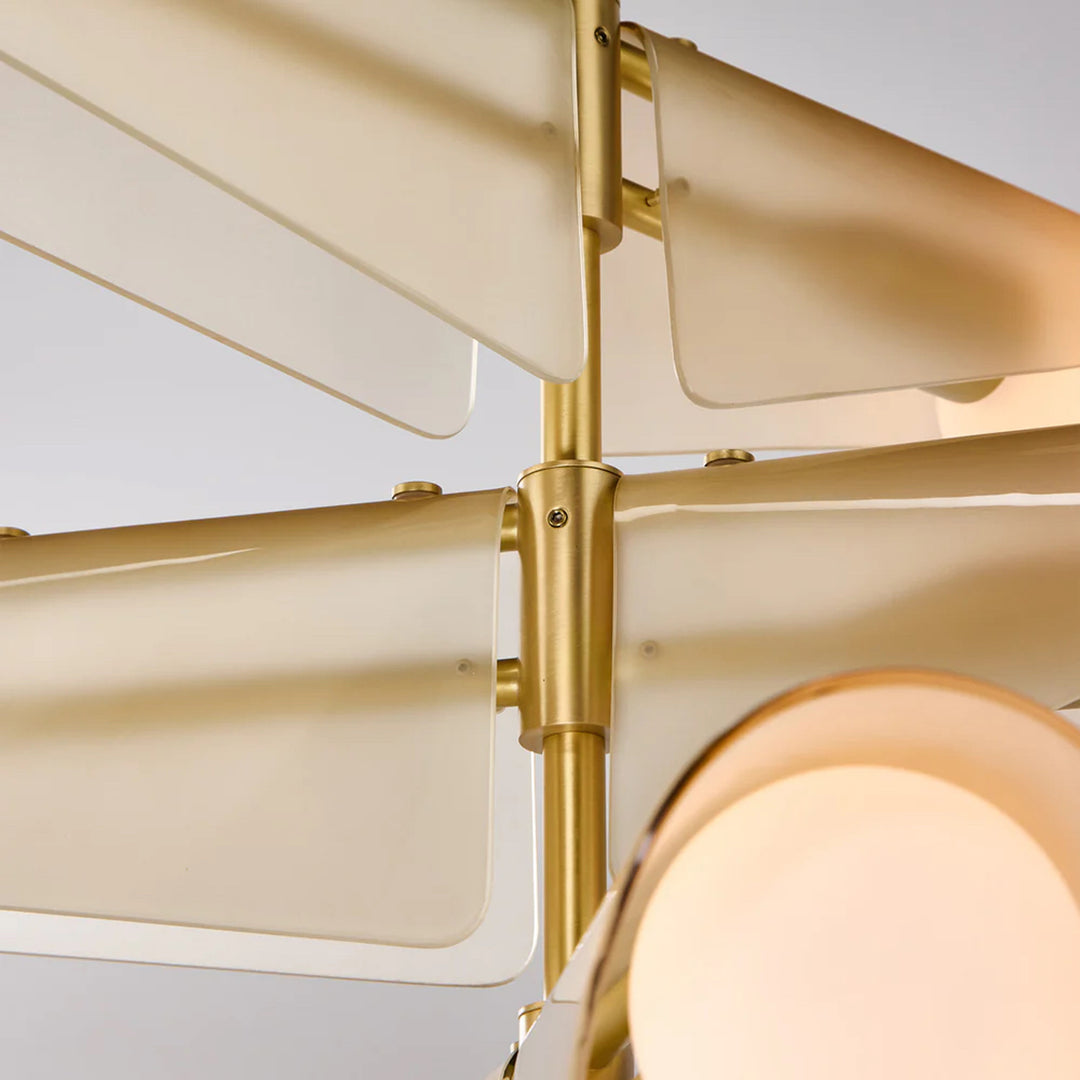 Close-up of a modern ceiling light fixture with gold accents and beige glass shades.
