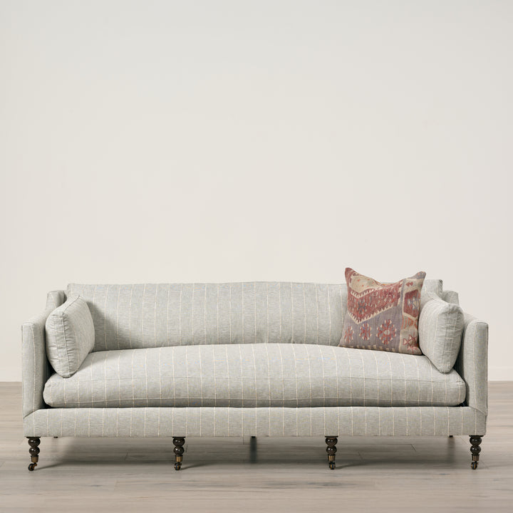 Gray sofa with decorative pillow on a neutral background
