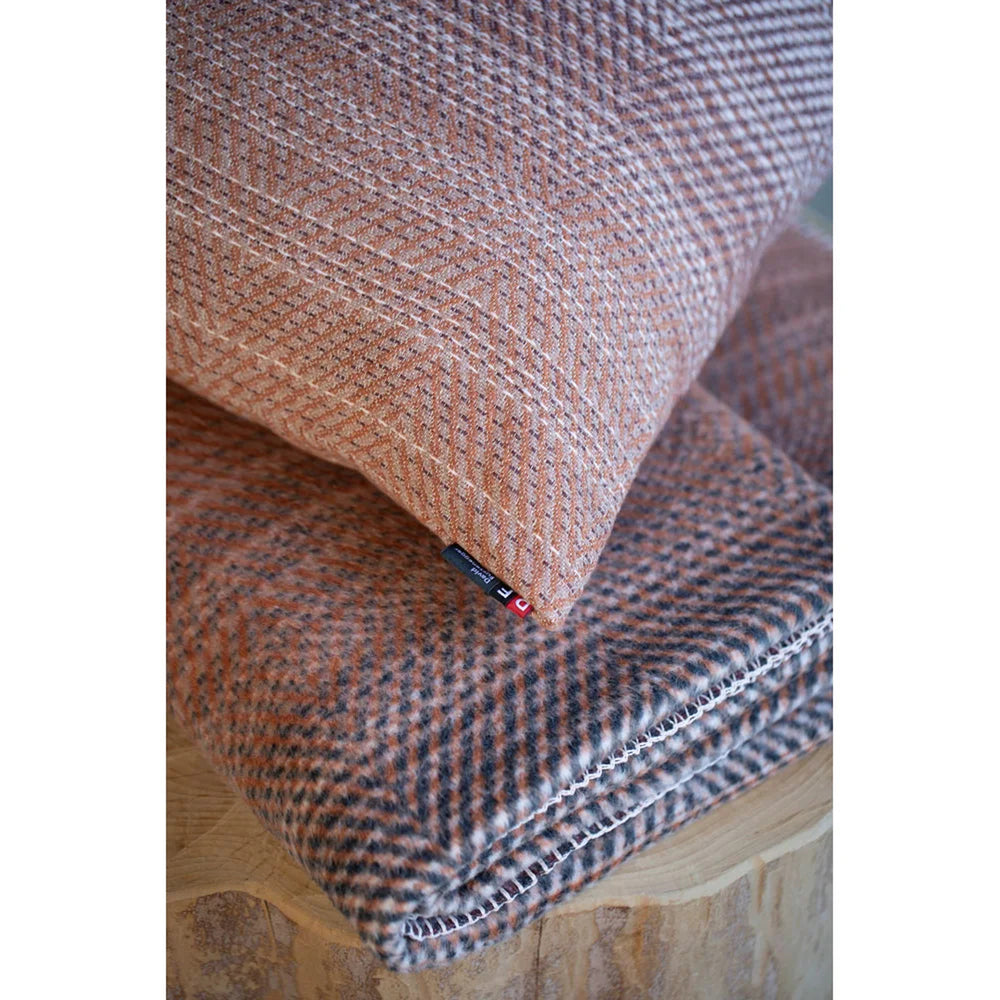 Textured pillow and blanket on a wooden surface