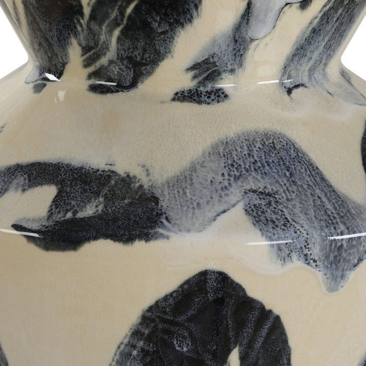 Close-up of a ceramic vase with black abstract patterns on a beige background