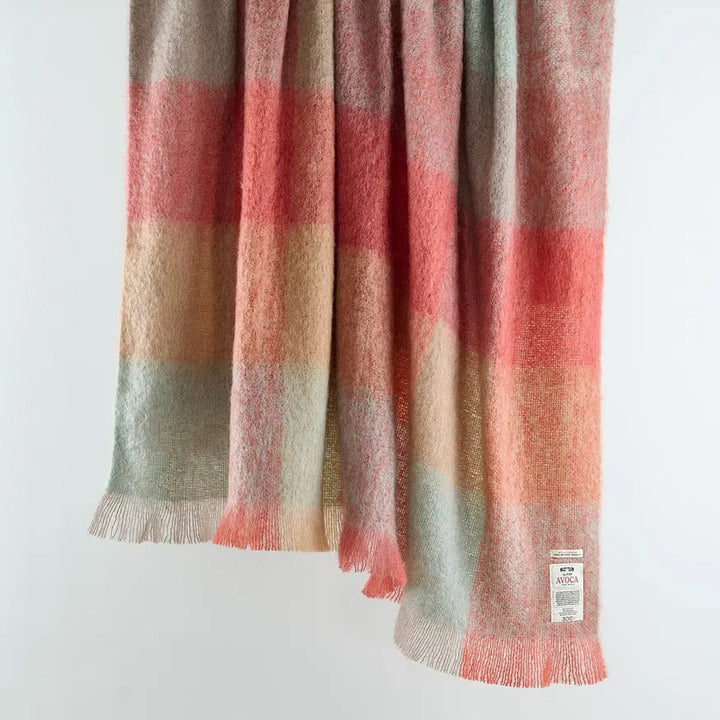 Plaid blanket with red, brown, and beige colors on a white background