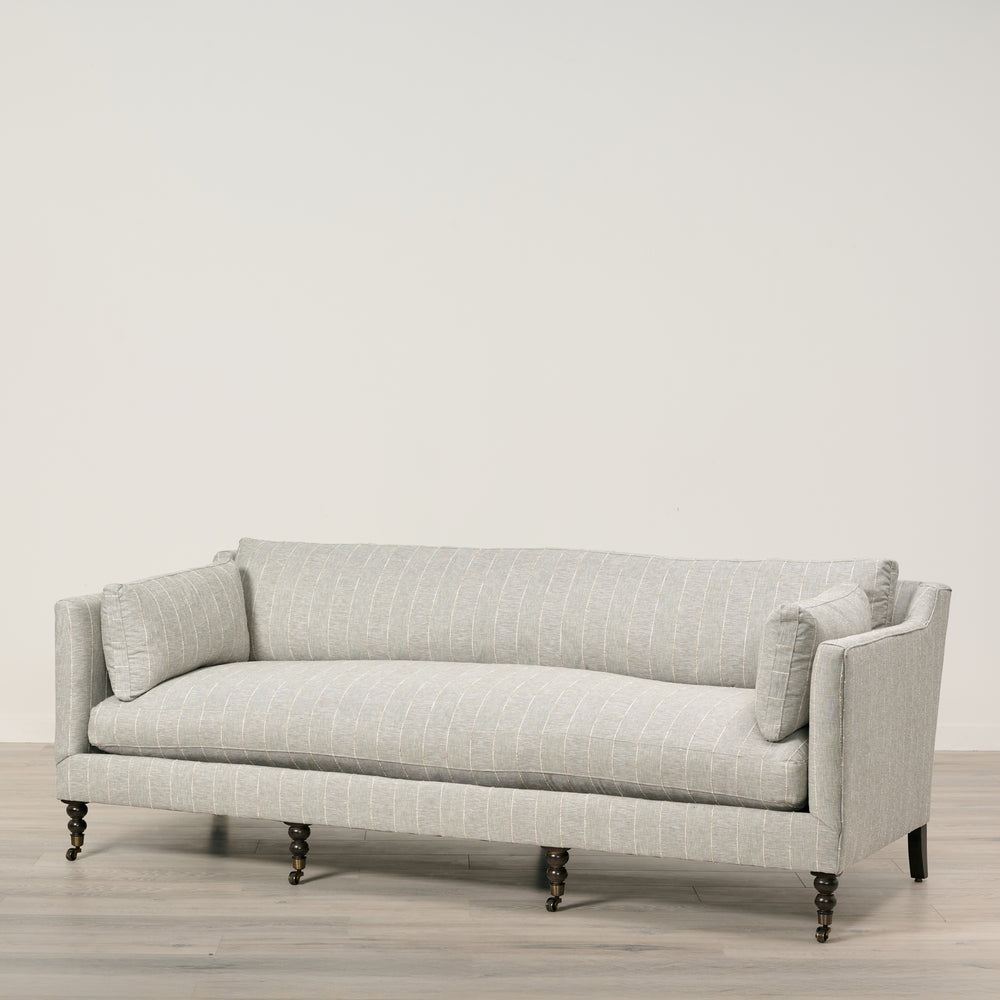 Light gray sofa with a subtle pattern on a wooden floor and light gray wall background