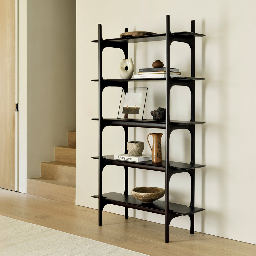 Black bookshelf with decorative items against a white wall