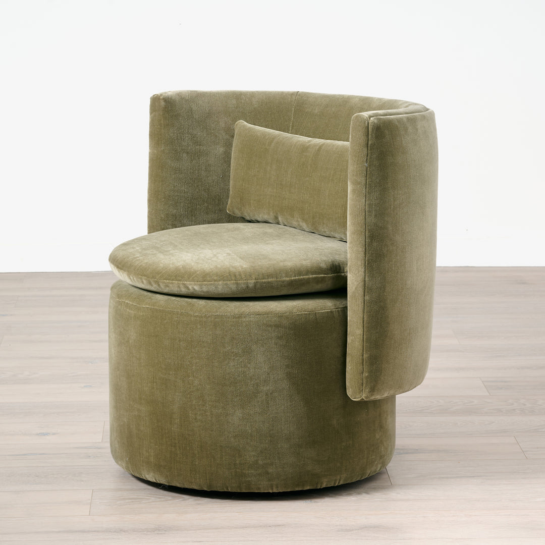 Green velvet chair on a wooden floor with a white background