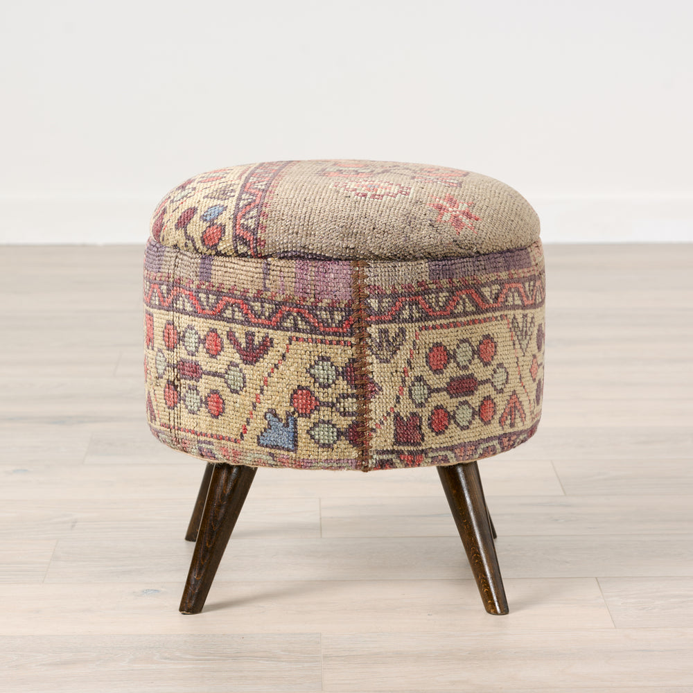 Round ottoman with patterned fabric cover on a wooden floor.Vintage Rug Small Ottoman 0725-A.